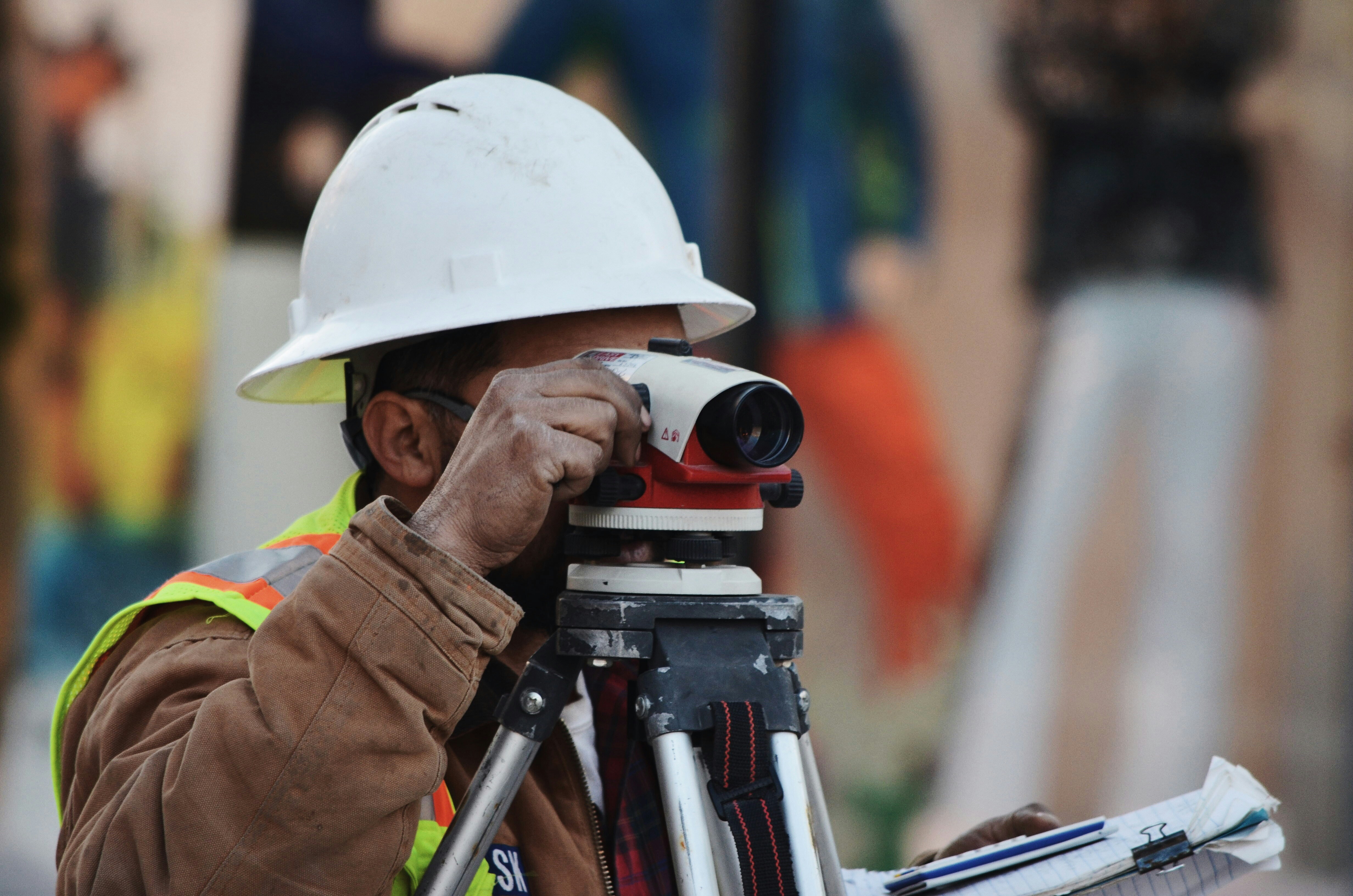 Specialist in a hard hat looking through a level